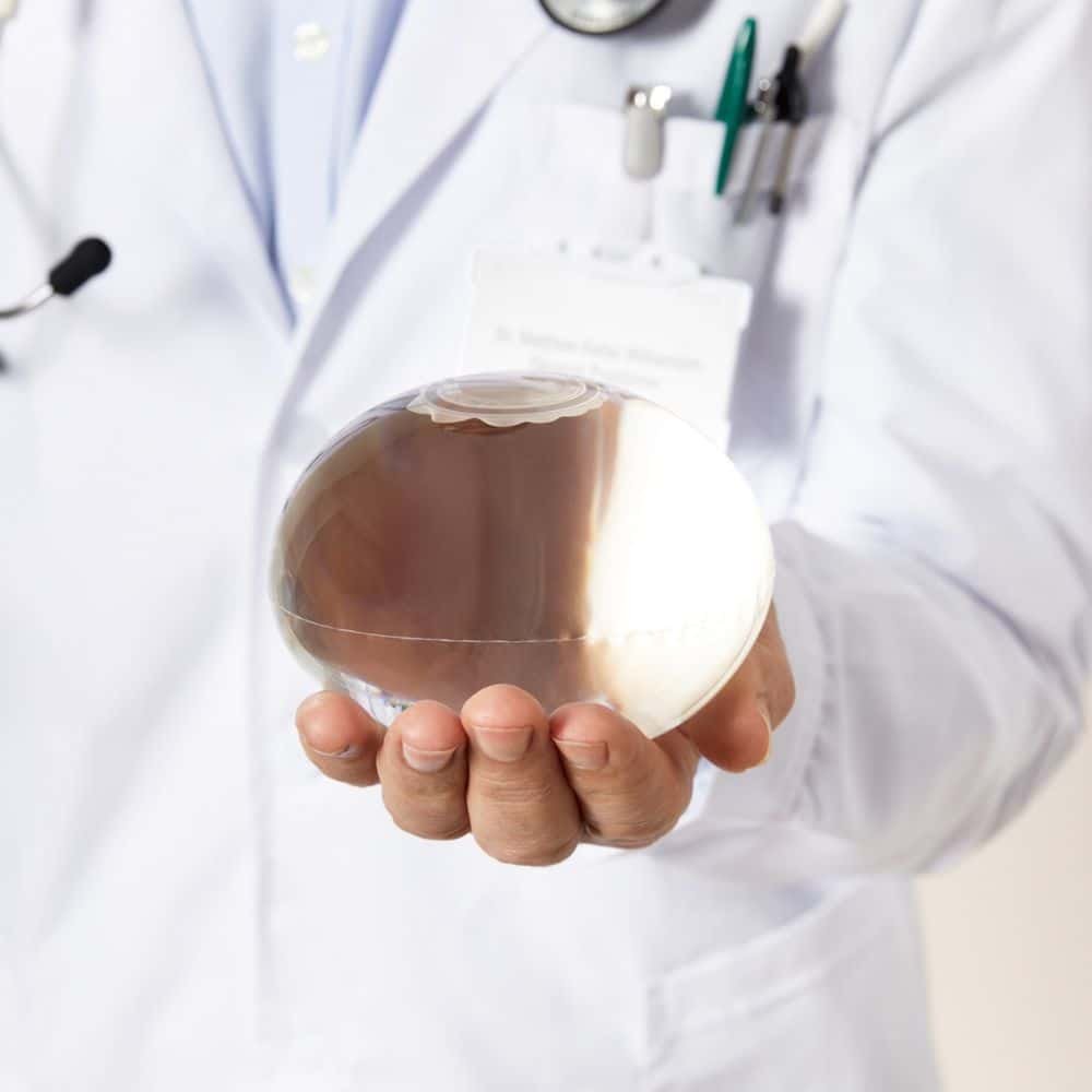 El Dr. Guihovany García sostiene una esfera de cristal en un entorno médico.